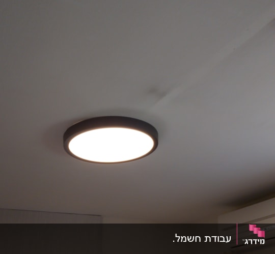 מנורת תקרה עגולה דולקת על תקרה לבנה